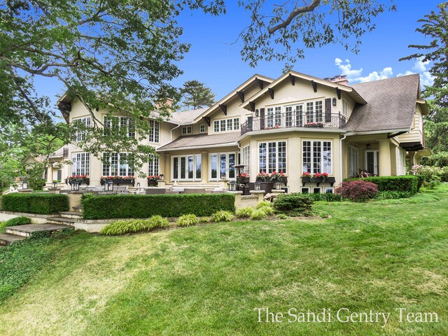 18635 N Fruitport Rd, Spring Lake, MI 49456 - back of property featuring french doors, a patio area, stucco siding, a chimney, and a yard
