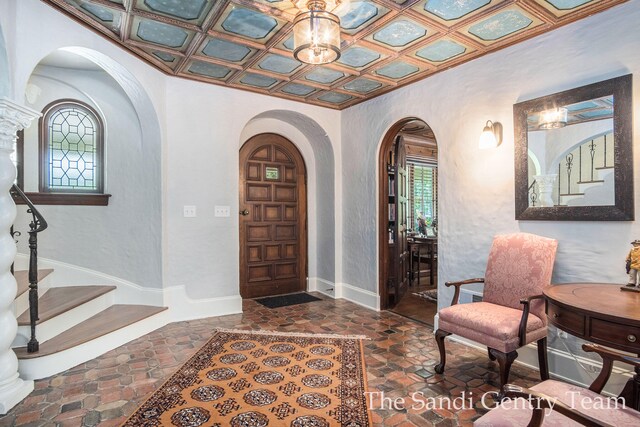 18635 N Fruitport Rd, Spring Lake, MI 49456 - foyer featuring arched walkways, stairway, dark stone finish floors, an ornate ceiling, and baseboards