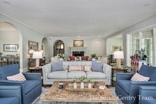 18635 N Fruitport Rd, Spring Lake, MI 49456 - living area featuring arched walkways, ornamental molding, wood finished floors, a fireplace, and baseboards