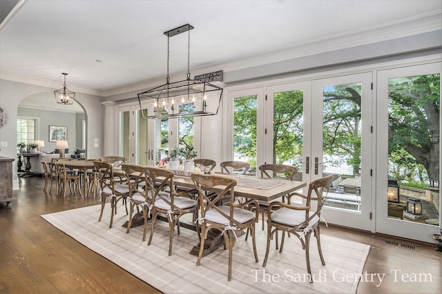 dining area with french doors, an inviting chandelier, crown molding, and hardwood / wood-style floors