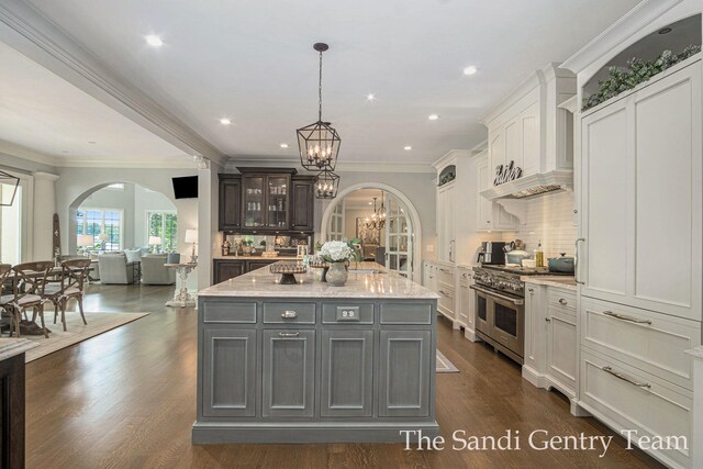 18635 N Fruitport Rd, Spring Lake, MI 49456 - kitchen with double oven range, arched walkways, a chandelier, custom exhaust hood, and ornamental molding