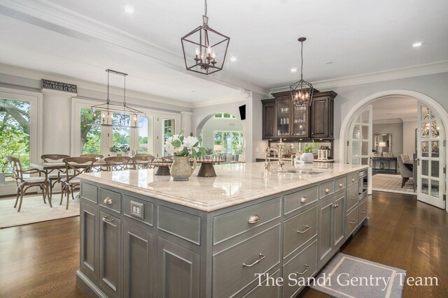 18635 N Fruitport Rd, Spring Lake, MI 49456 - kitchen featuring a sink, arched walkways, a spacious island, light stone countertops, and ornamental molding