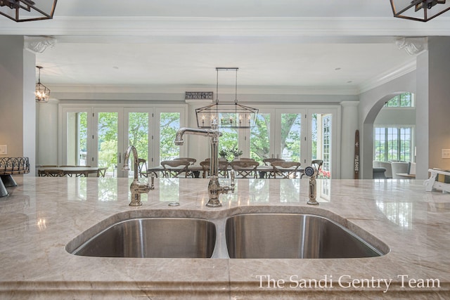 kitchen featuring a wealth of natural light, sink, light stone countertops, and french doors