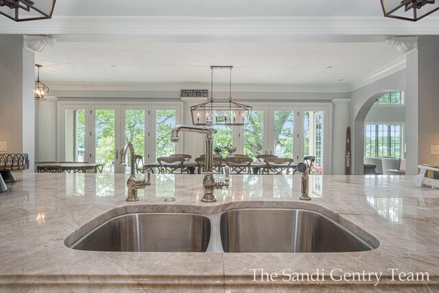 18635 N Fruitport Rd, Spring Lake, MI 49456 - kitchen view of a sink, light stone countertops, french doors, arched walkways, and ornamental molding