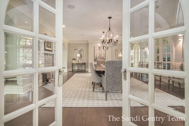 dining room featuring french doors, vaulted ceiling, dark hardwood / wood-style floors, ornamental molding, and a chandelier