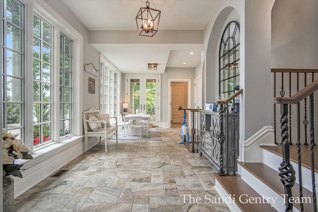 entrance foyer featuring french doors and a notable chandelier