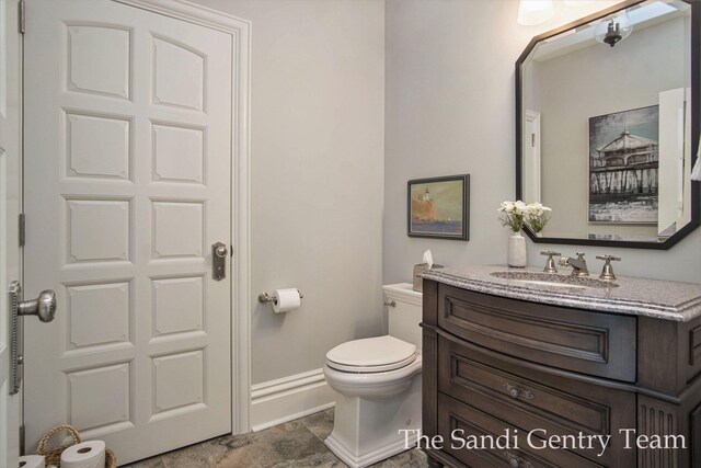 18635 N Fruitport Rd, Spring Lake, MI 49456 - half bathroom featuring vanity, toilet, and baseboards