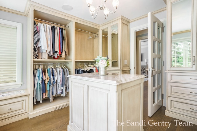 walk in closet featuring a chandelier and dark wood-type flooring