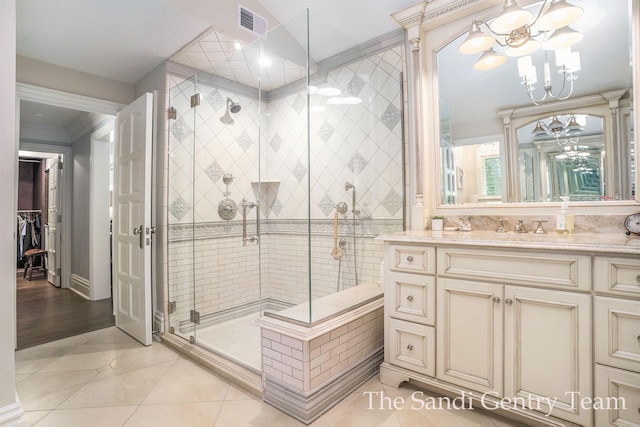 bathroom with tile patterned floors, vanity, crown molding, a notable chandelier, and a shower with shower door