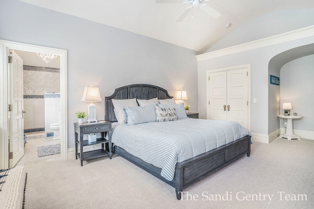 bedroom with carpet flooring, connected bathroom, ceiling fan, vaulted ceiling, and a closet