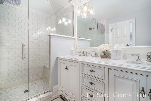 bathroom featuring a shower with door and vanity