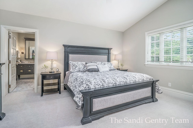 carpeted bedroom featuring connected bathroom and vaulted ceiling