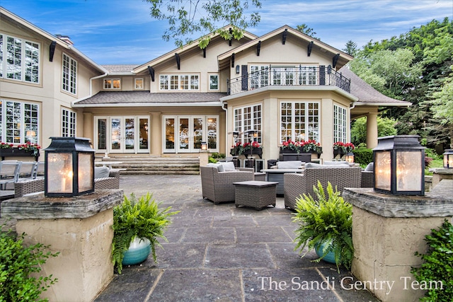 view of patio / terrace featuring an outdoor living space with a fireplace and a balcony