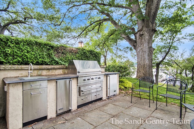 view of patio / terrace with sink, an outdoor kitchen, and a grill