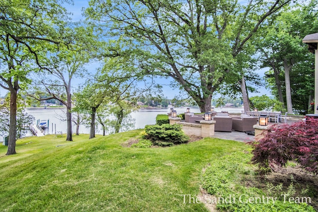 view of yard with outdoor lounge area and a water view