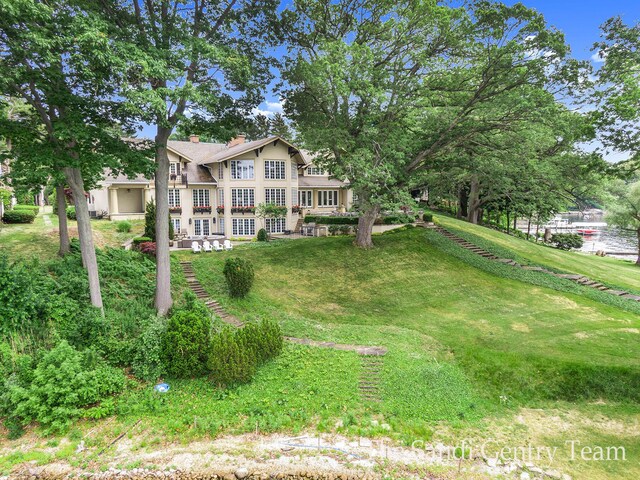 18635 N Fruitport Rd, Spring Lake, MI 49456 - view of front of home featuring a chimney and a front yard