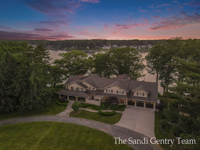 aerial view at dusk featuring a water view