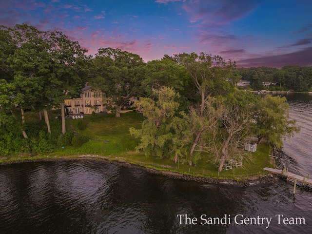 aerial view at dusk featuring a water view