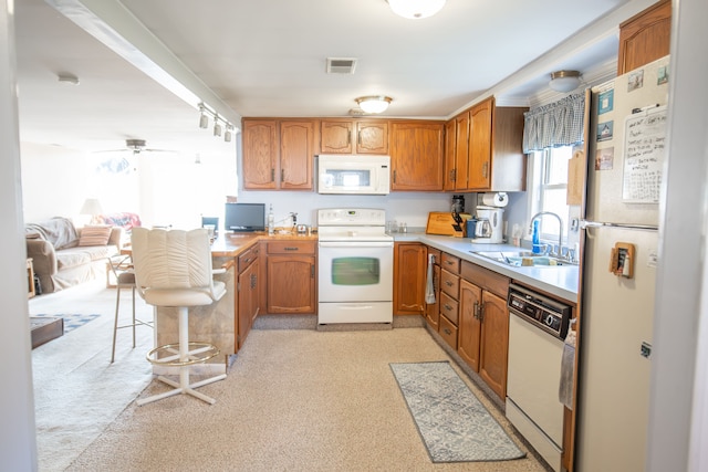 kitchen featuring light carpet, white appliances, ceiling fan, and sink