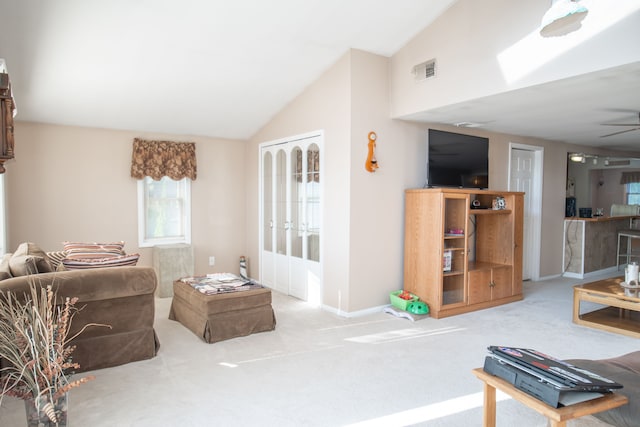 living room with ceiling fan, light colored carpet, and lofted ceiling