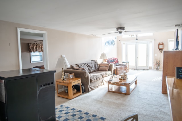 living room featuring ceiling fan, light colored carpet, and french doors