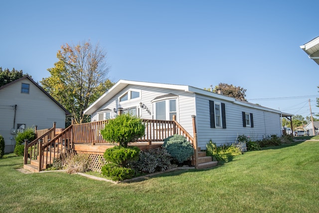 rear view of house featuring a yard and a wooden deck