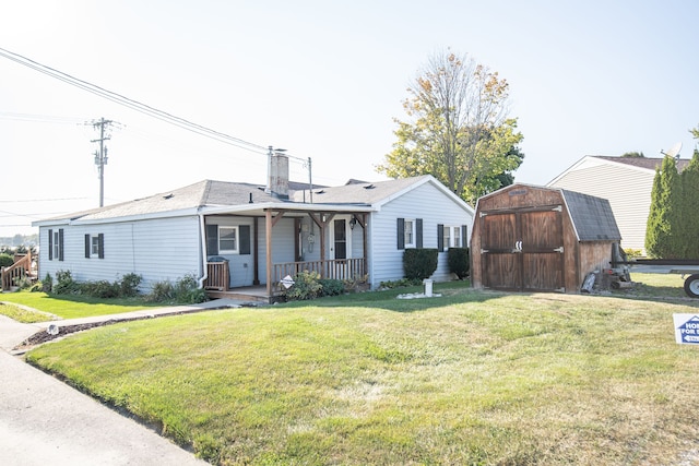 single story home featuring covered porch, a front yard, and a storage unit