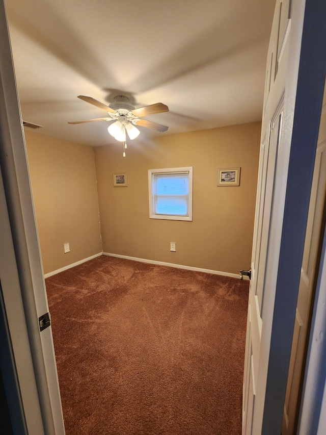 carpeted spare room featuring ceiling fan