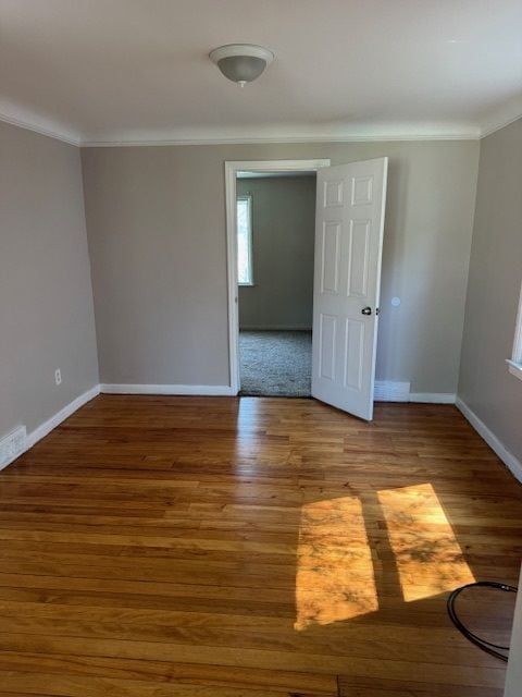 unfurnished room featuring hardwood / wood-style flooring and ornamental molding