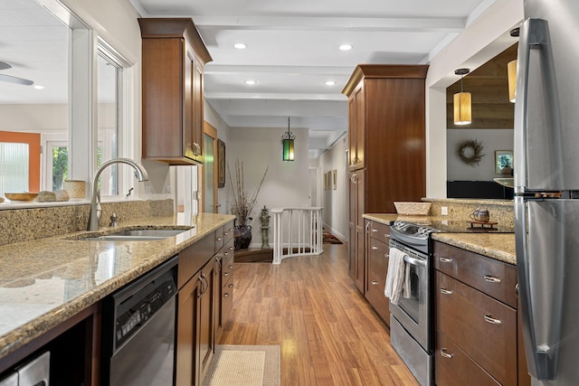 kitchen with pendant lighting, sink, light hardwood / wood-style floors, appliances with stainless steel finishes, and beam ceiling