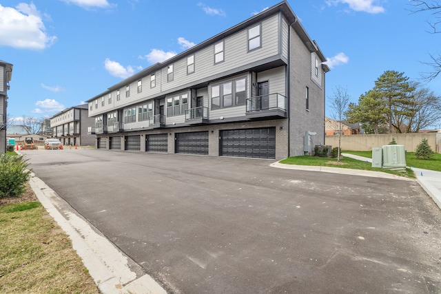 exterior space featuring cooling unit, a garage, a balcony, and central AC