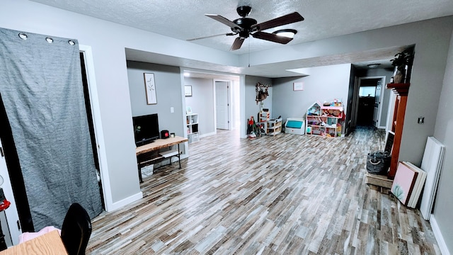491 Bitter Creek Ln, Pierson, MI 49339 - living room with wood finished floors, ceiling fan, baseboards, and a textured ceiling