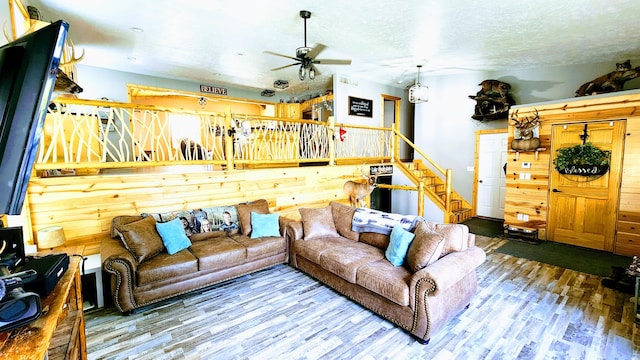 491 Bitter Creek Ln, Pierson, MI 49339 - living room with a ceiling fan, wood finished floors, stairs, and a textured ceiling