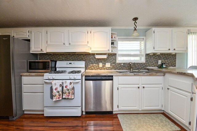 kitchen featuring pendant lighting, dark wood-type flooring, white cabinets, sink, and appliances with stainless steel finishes