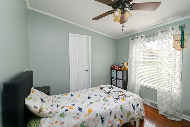 bedroom featuring crown molding, ceiling fan, and dark wood-type flooring