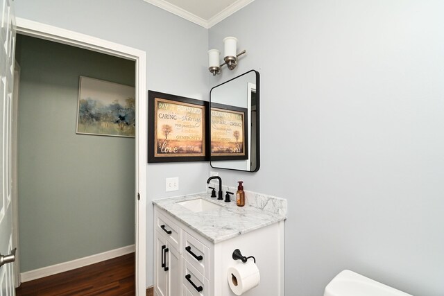 bathroom with vanity, hardwood / wood-style flooring, toilet, and ornamental molding
