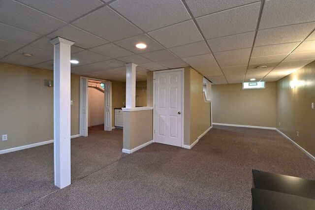 basement with a paneled ceiling and carpet