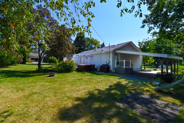 view of home's exterior with a lawn and a fire pit