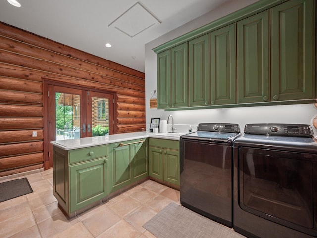 laundry area featuring cabinets, separate washer and dryer, sink, and log walls