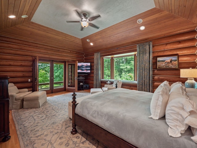 bedroom featuring access to outside, multiple windows, lofted ceiling, and light wood-type flooring