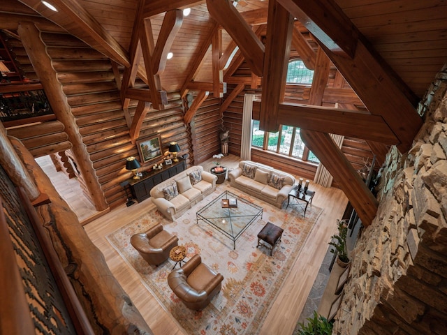 unfurnished living room with vaulted ceiling with beams, hardwood / wood-style flooring, rustic walls, and wood ceiling