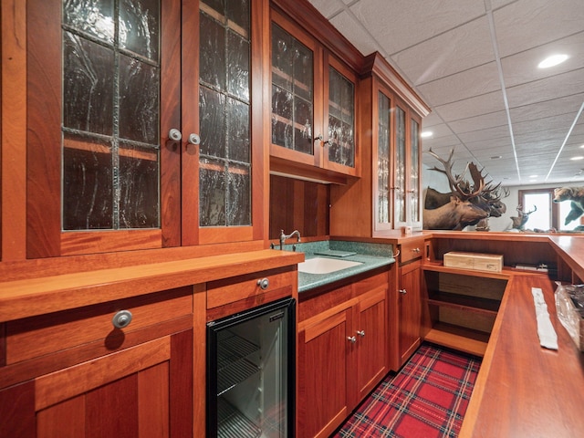 bar featuring wine cooler, sink, and a drop ceiling