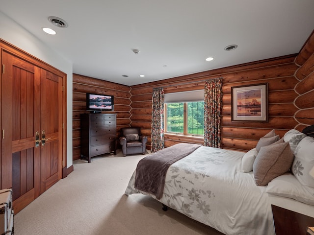 bedroom with light colored carpet, rustic walls, and a closet