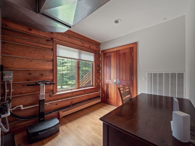 office with light hardwood / wood-style flooring and rustic walls