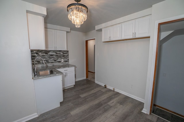 kitchen featuring dark wood-type flooring, stone counters, sink, tasteful backsplash, and white cabinetry