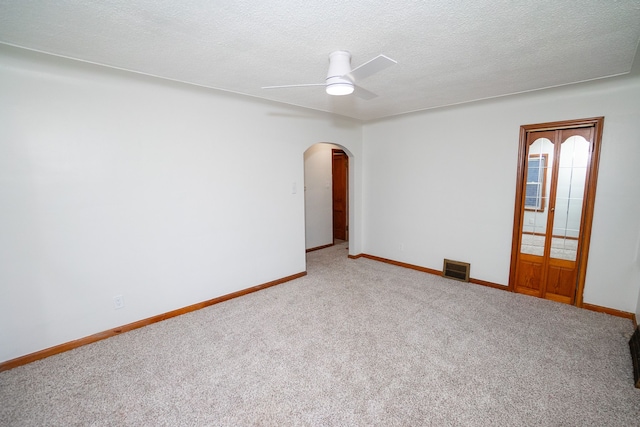 carpeted spare room featuring ceiling fan and a textured ceiling