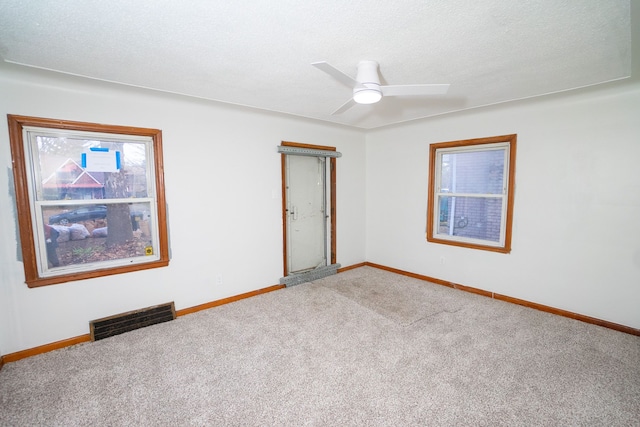 unfurnished room with carpet flooring, ceiling fan, and a textured ceiling