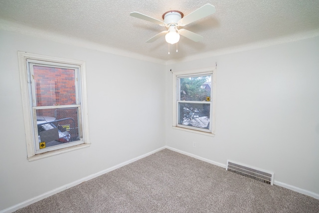 carpeted spare room with ceiling fan and a textured ceiling