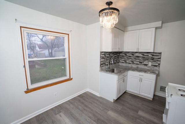 kitchen featuring white range with electric cooktop, decorative light fixtures, white cabinetry, and dark hardwood / wood-style floors