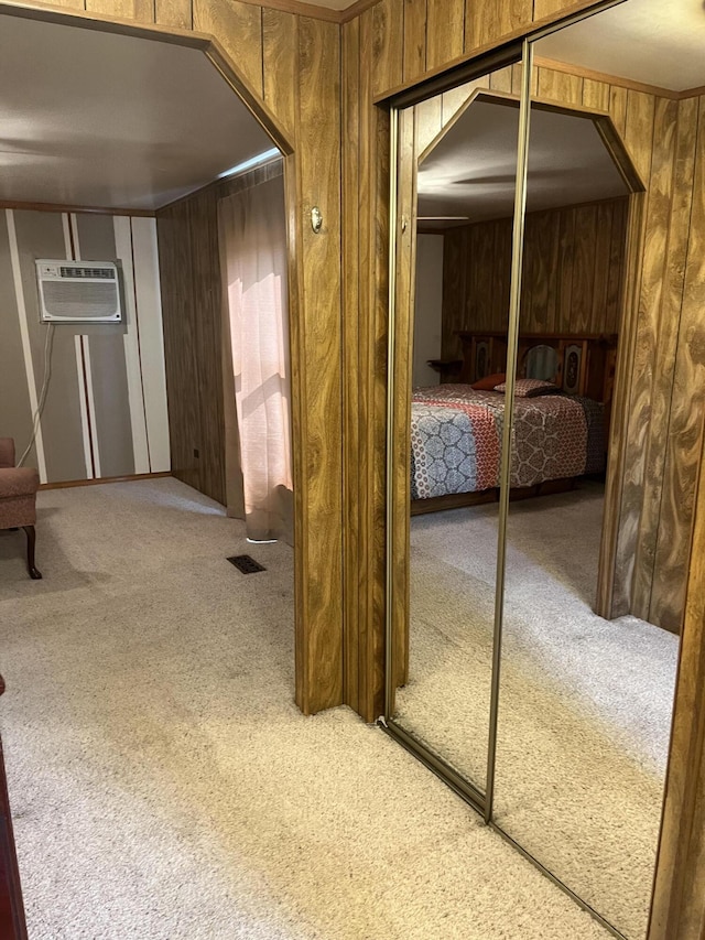 hallway featuring carpet floors, a wall mounted AC, and wooden walls